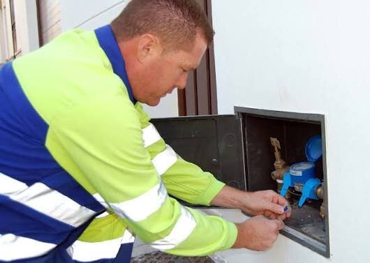 Técnico instalando hidrômetro certificado